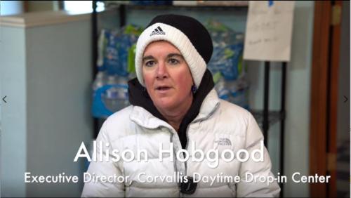 A woman wearing a white coat and a black and white beanie.