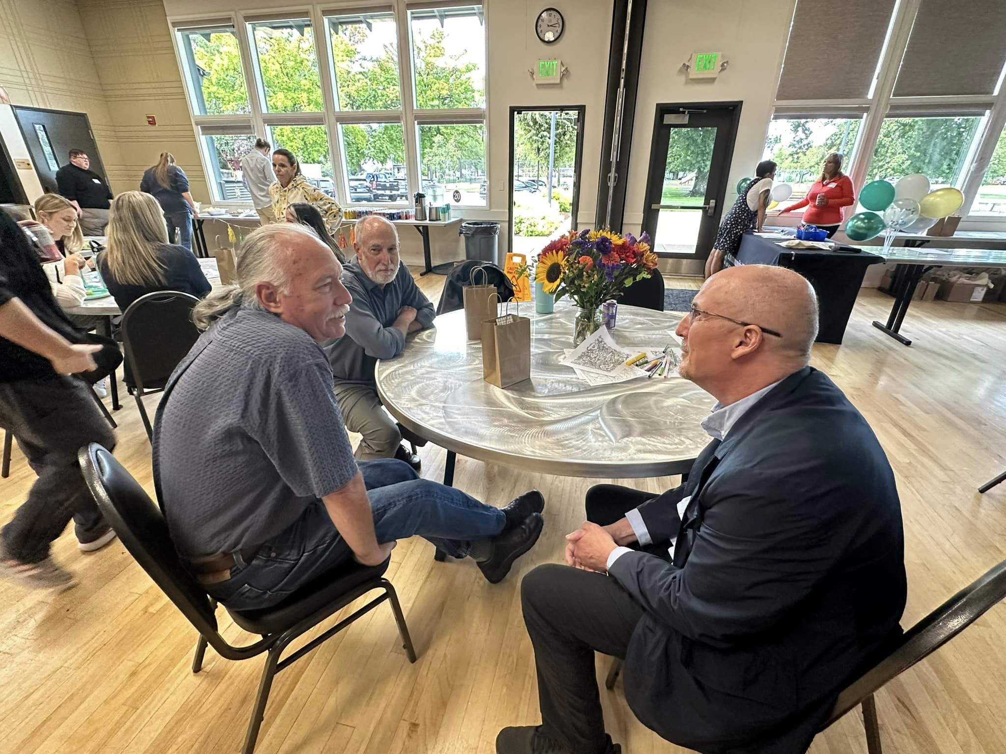 Three men talking at a table.