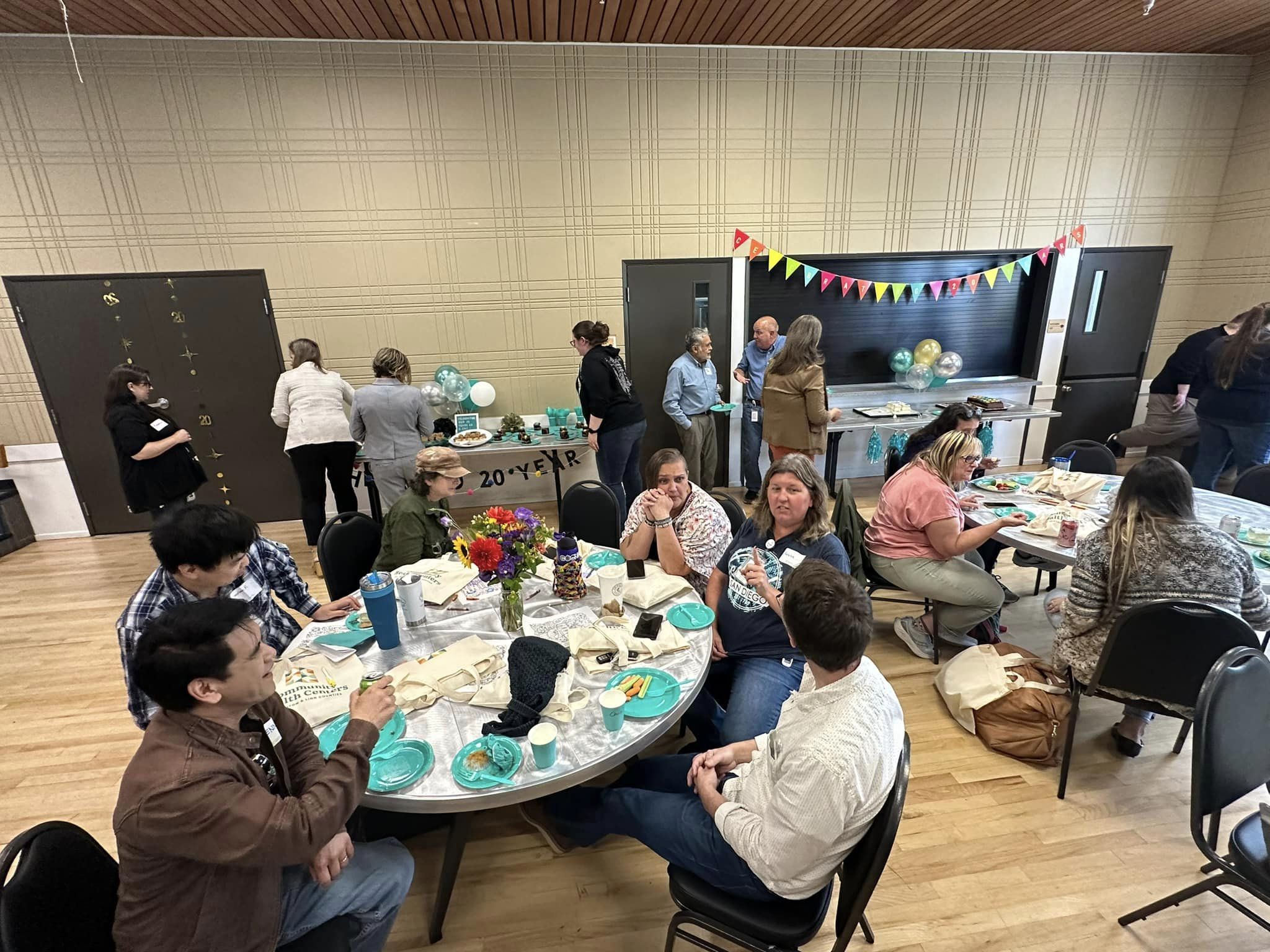 People enjoying food and cake surrounded by celebratory décor.