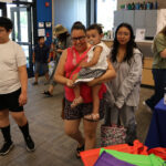 Adults, teenagers, and children walking through a lobby entrance.