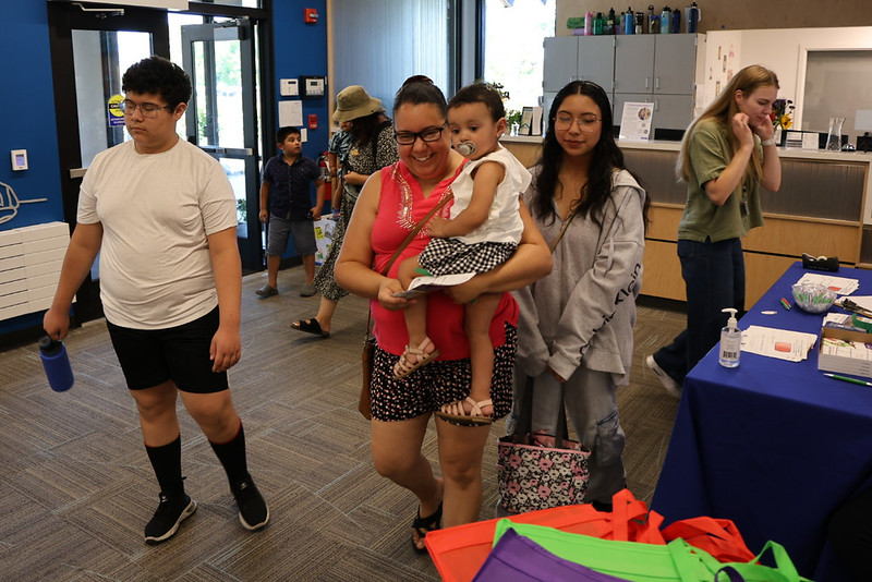 Adults, teenagers, and children walking through a lobby entrance.