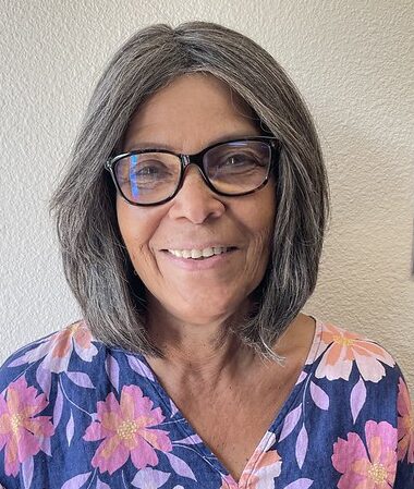 A woman with shoulder-length hair wearing a floral top.