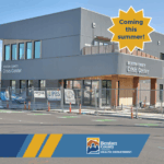 The Benton County Crisis Center building surrounded by a construction fence. A gold star outlined in white with dark blue text reads, "Coming this summer!"