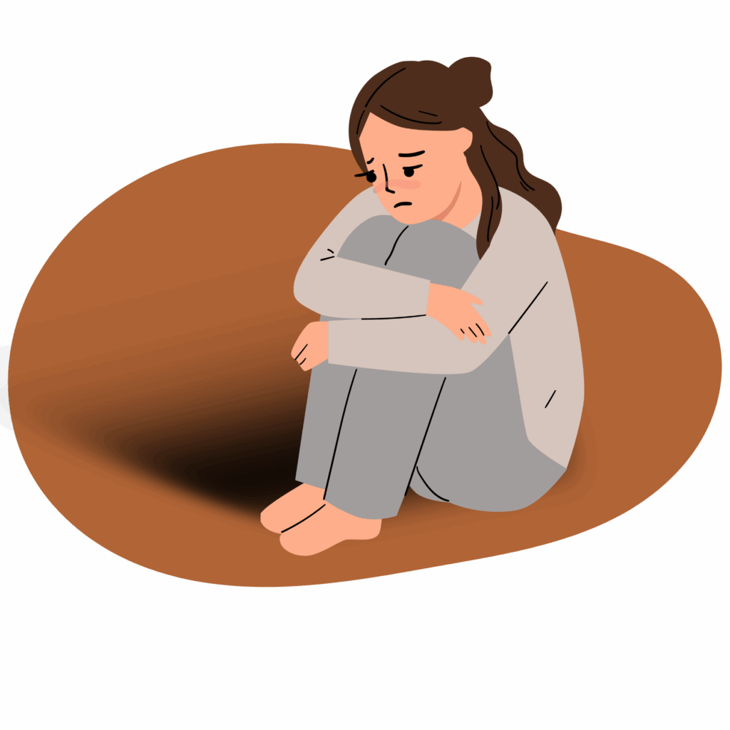 A sad person with long hair is sitting and holding their knees to their chest