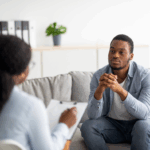 A person meeting with a psychiatrist in their office. / Una persona consulta con un psiquiatra en su consultorio.