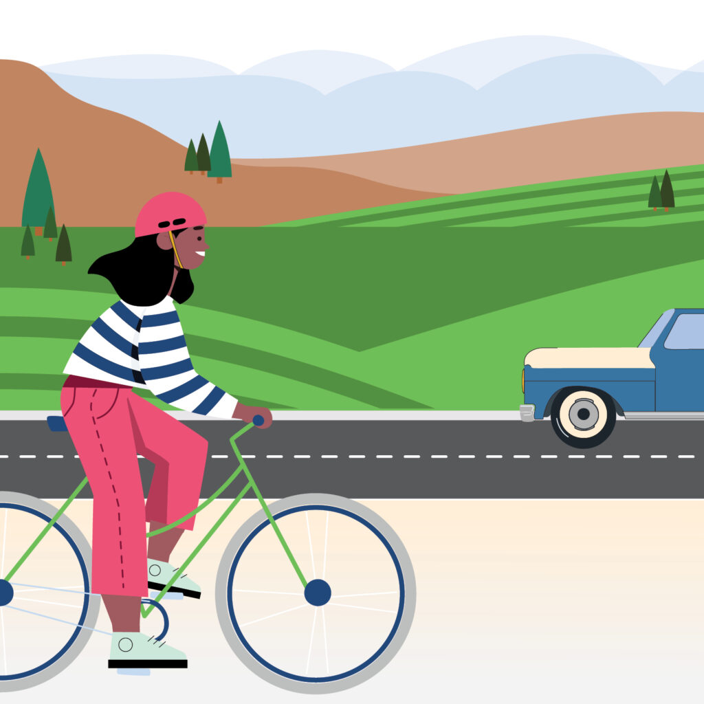 An illustration of a person riding a bike on a path near a road with green grass, trees, and hills in the background. / Ilustración de una persona en bicicleta por un sendero cerca de una carretera con césped verde, árboles y colinas al fondo.