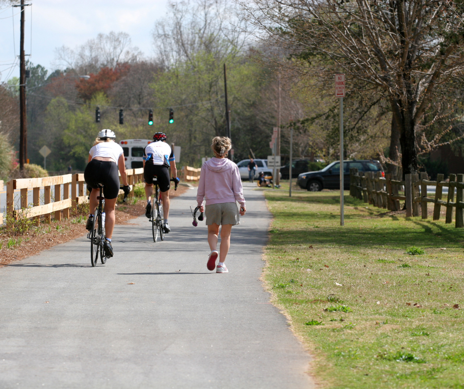 People walking and biking on a neighborhood path.